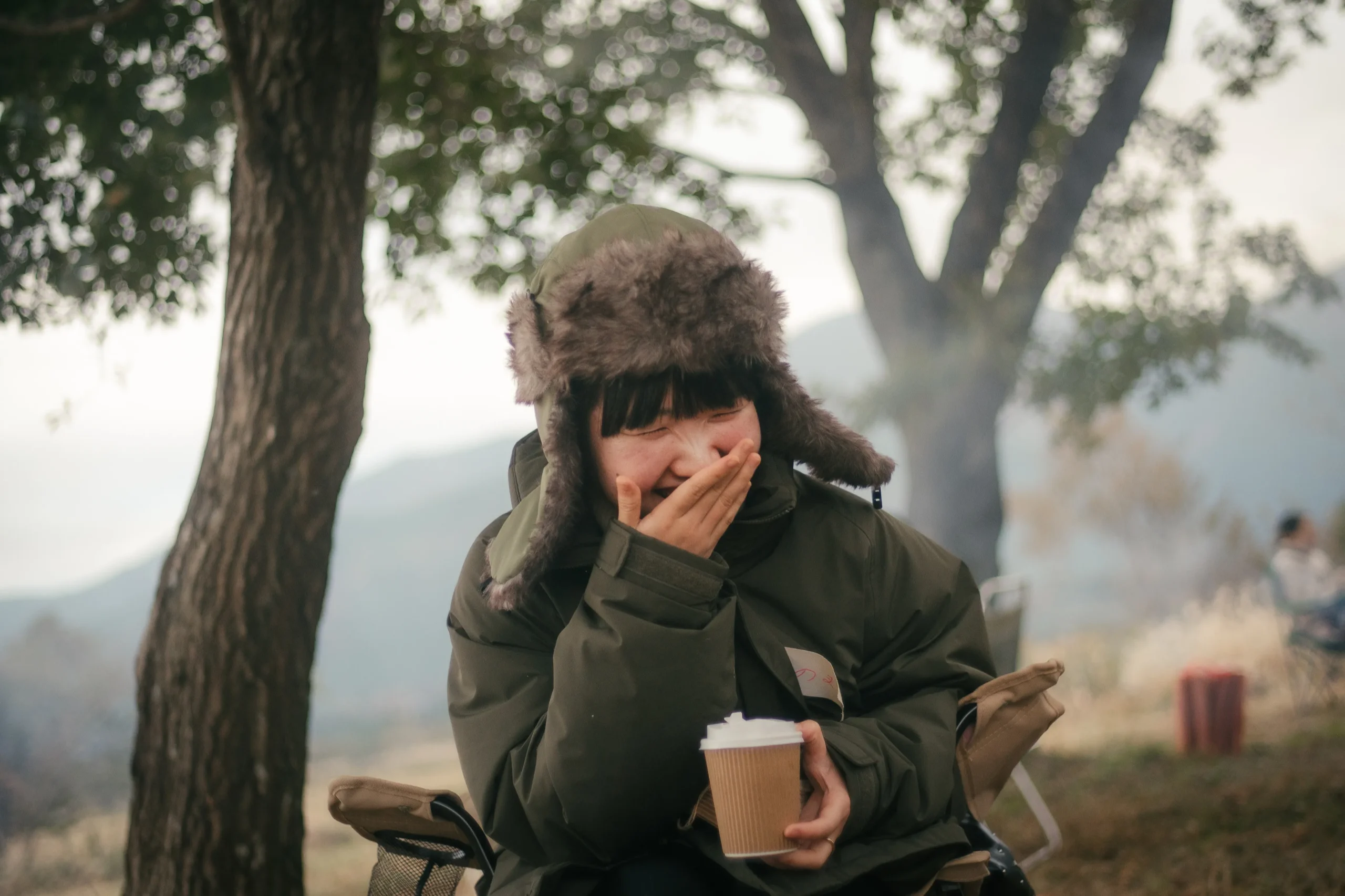 コーヒーカップを手に屋外でくつろぐ参加者