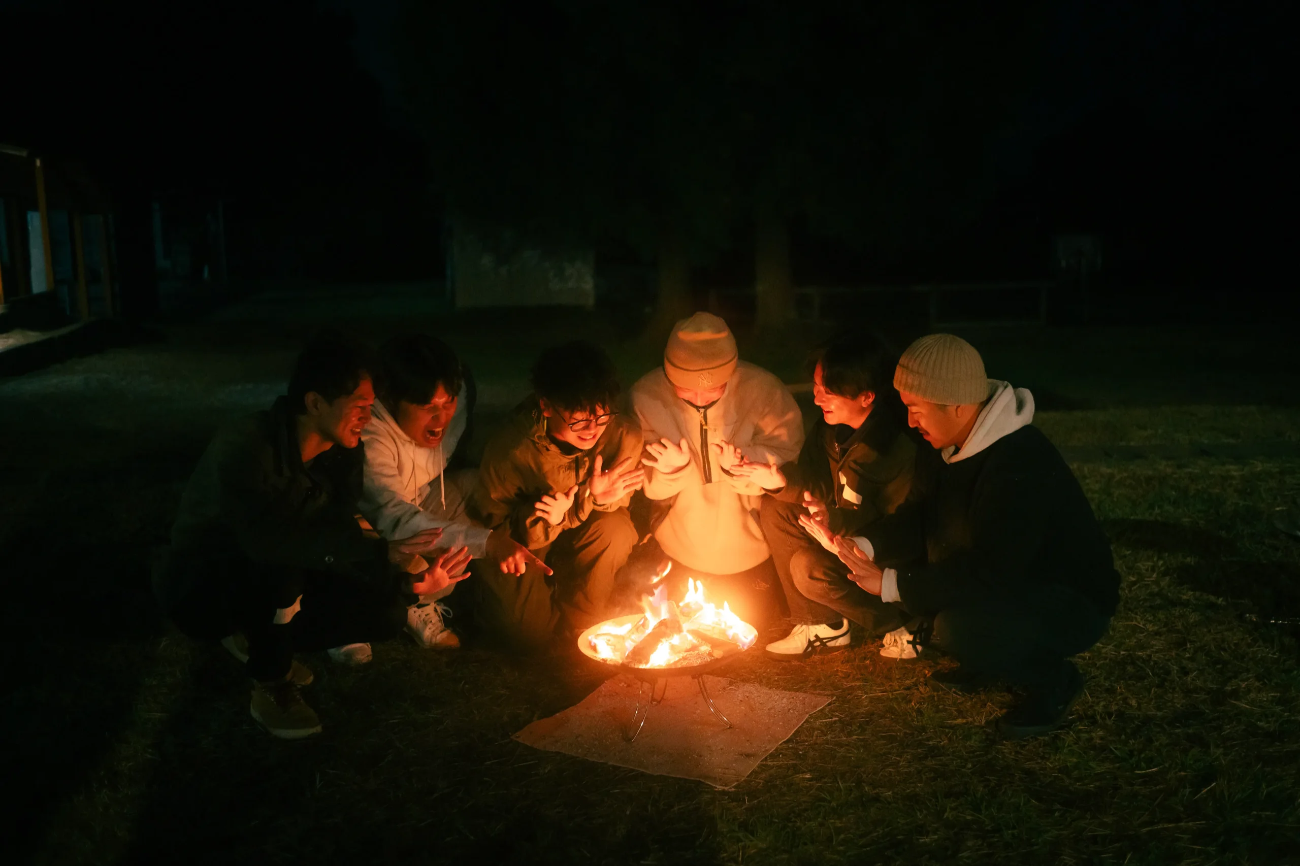夜の焚き火を囲む参加者たち